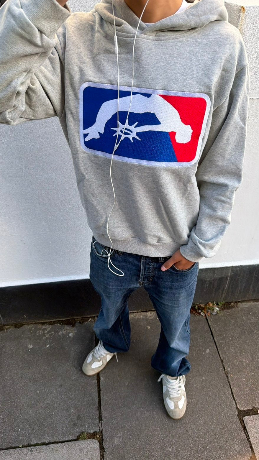 Solaire Hoodie in grey worn outdoors with blue jeans, front view